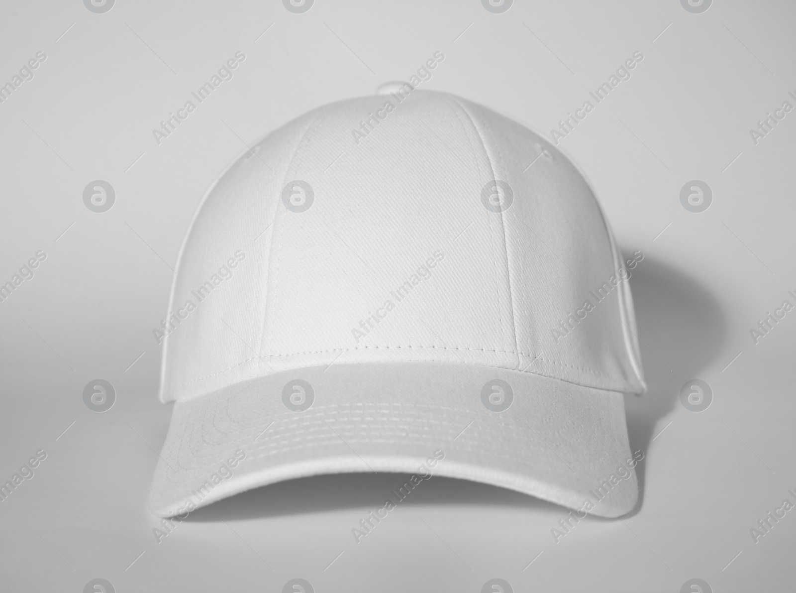 Photo of Stylish white baseball cap on light background