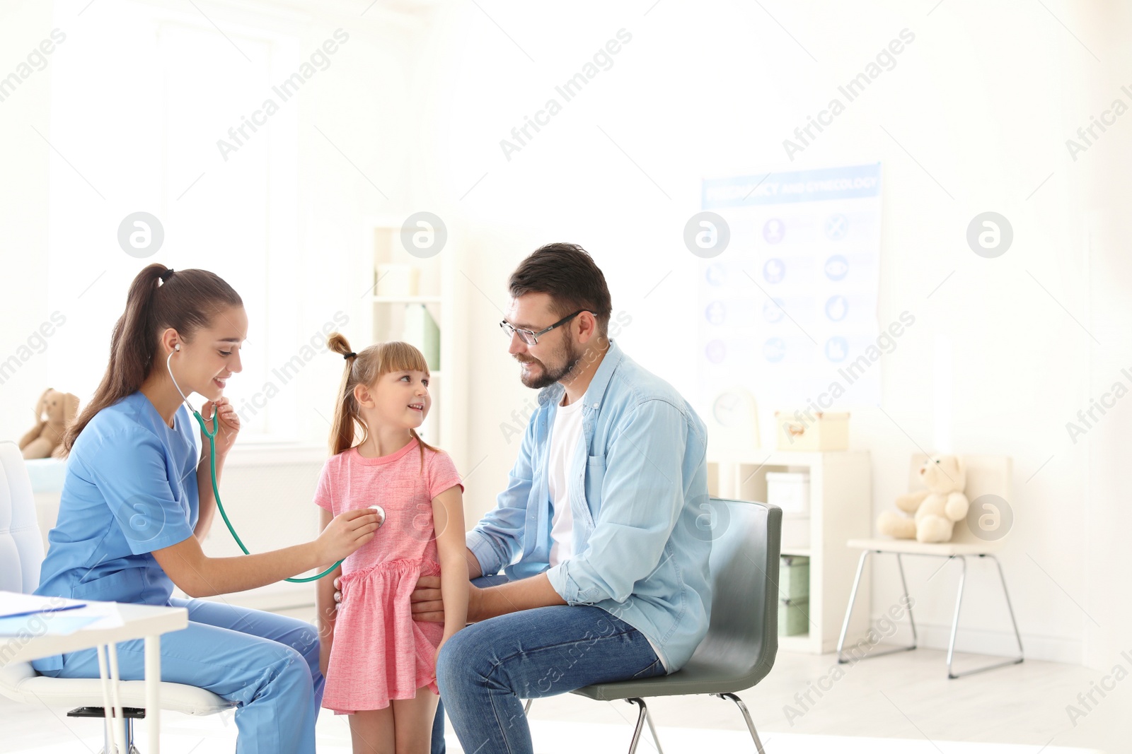 Photo of Children's doctor examining little girl with stethoscope in hospital. Space for text