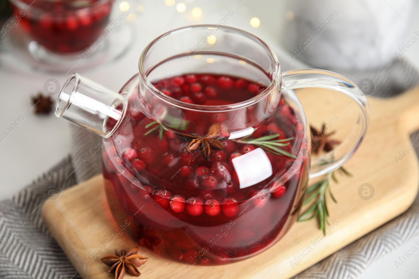 Photo of Tasty hot cranberry tea with rosemary and anise on table