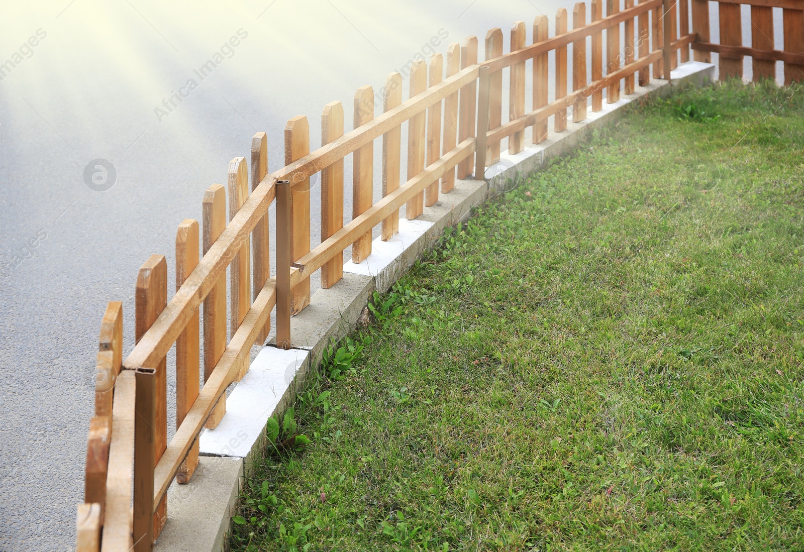 Photo of Small wooden fence near green grass outdoors