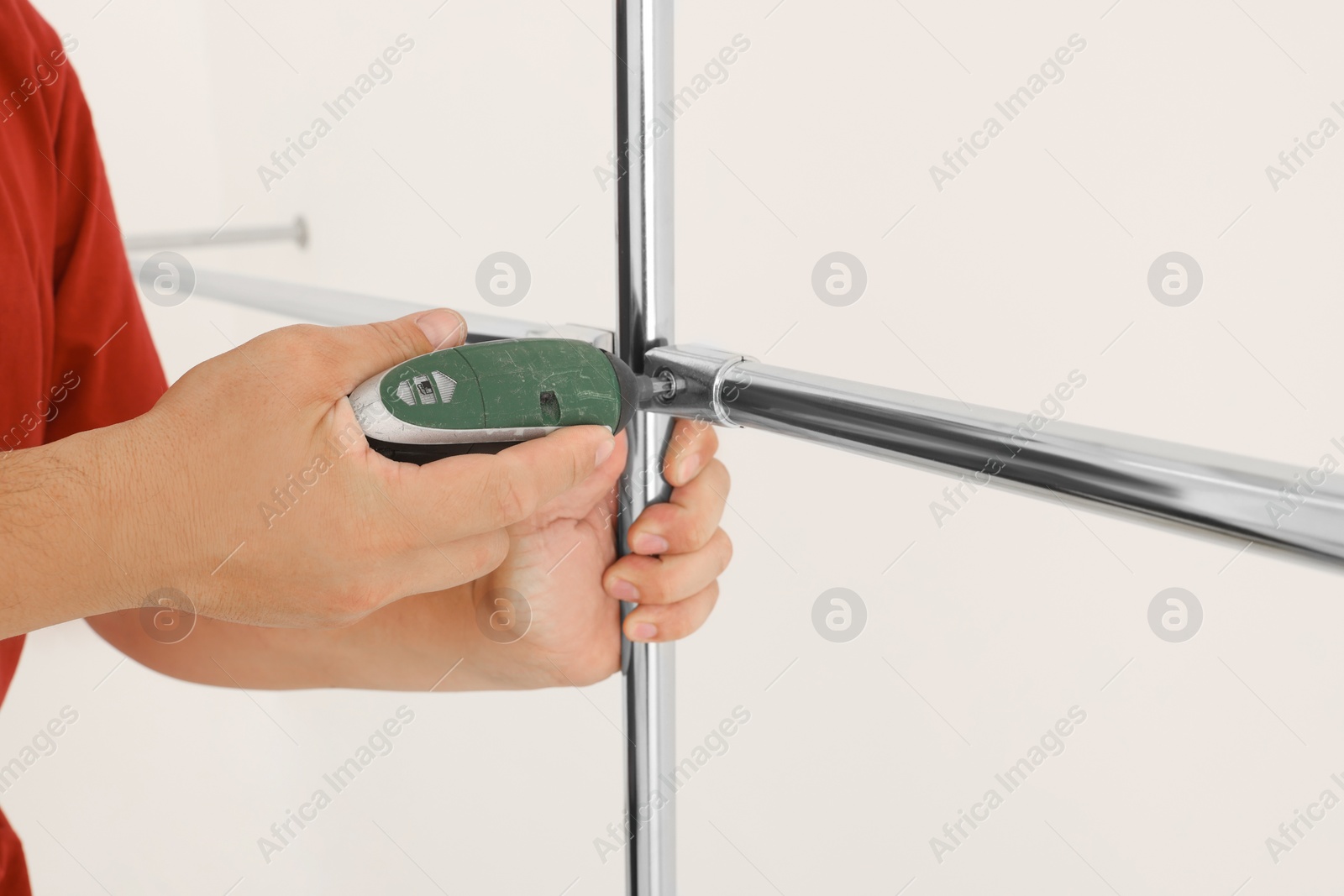 Photo of Worker installing new metal pipes indoors, closeup