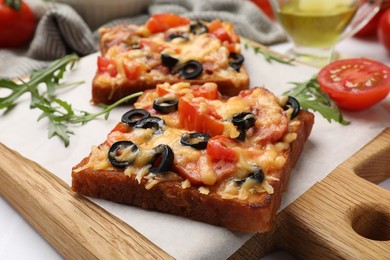 Tasty pizza toasts and ingredients on white table, closeup