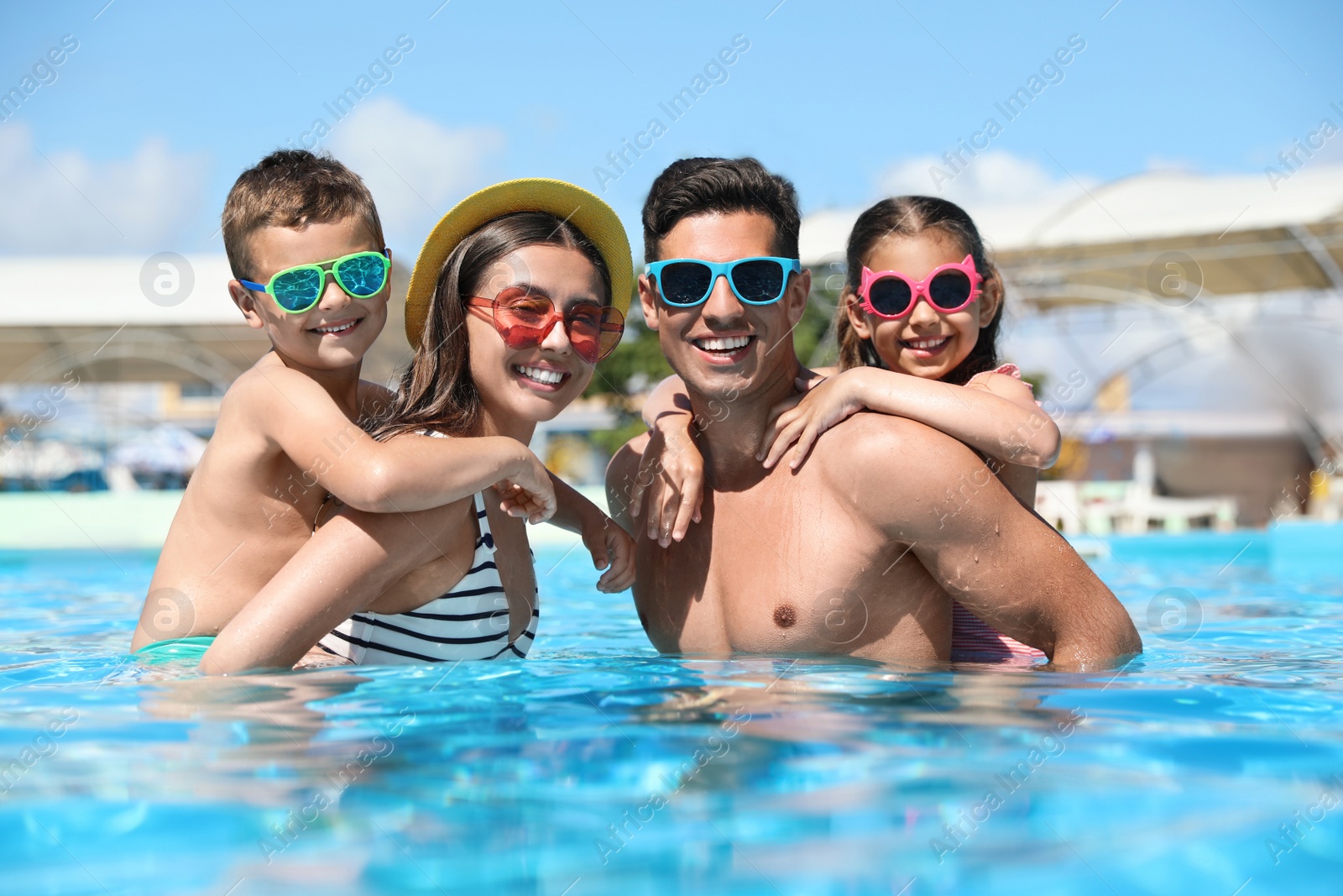 Photo of Happy family in swimming pool. Summer vacation