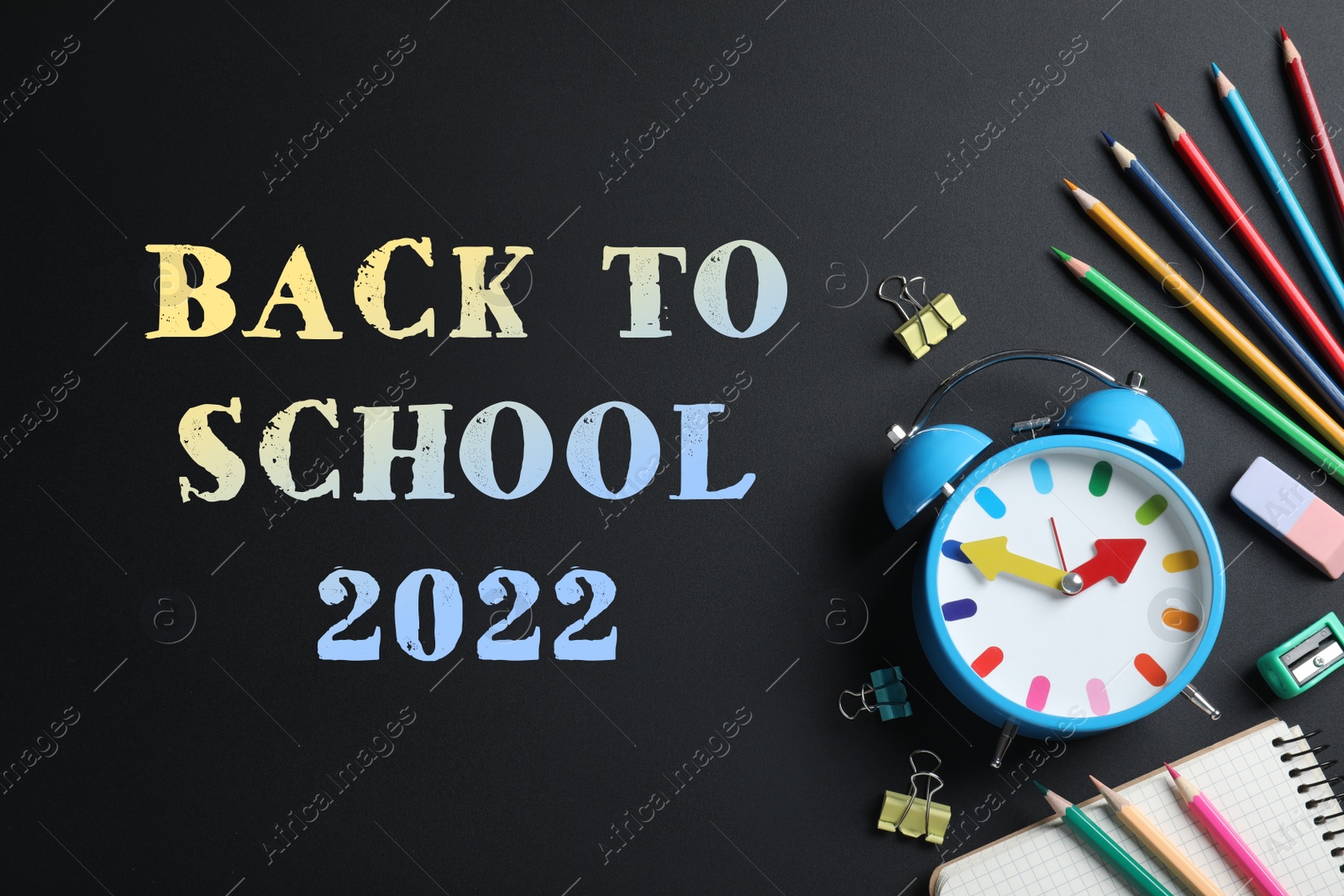 Image of Back to school 2022. Flat lay composition with alarm clock and different stationery on black background