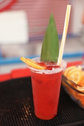 Photo of Delicious refreshing drink in plastic cup on bar counter