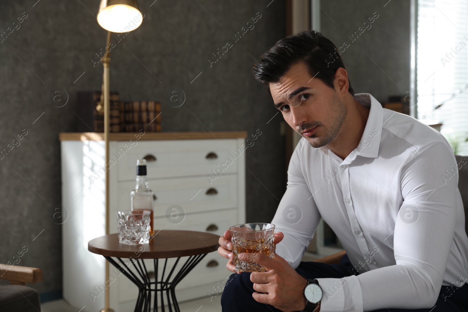 Photo of Man near table with whiskey at home