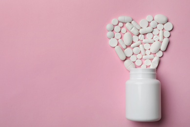 Bottle and heart of pills on color background, flat lay. Space for text