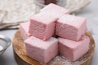 Tasty marshmallows with powder sugar on white table, closeup