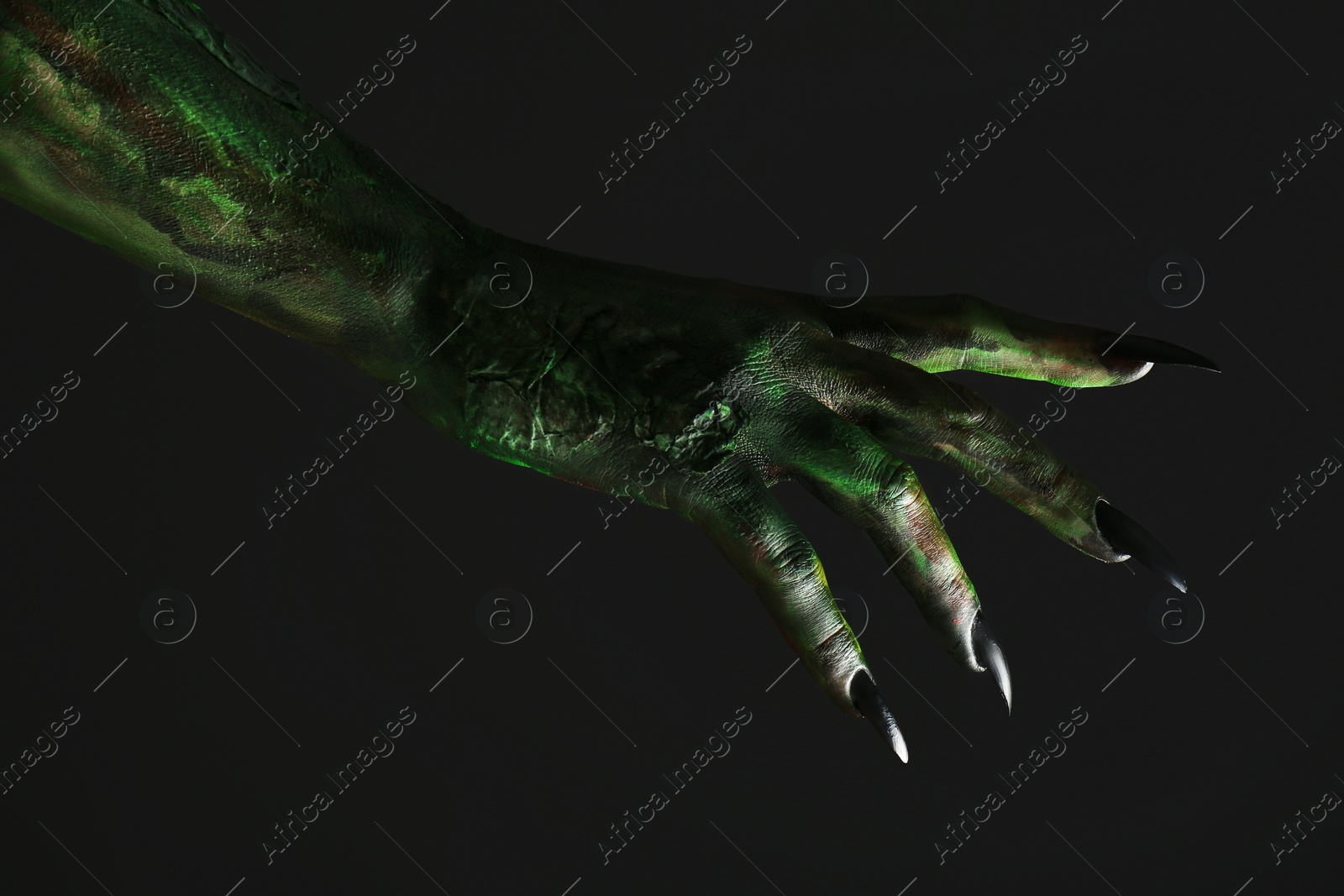 Photo of Scary monster on black background, closeup of hand. Halloween character