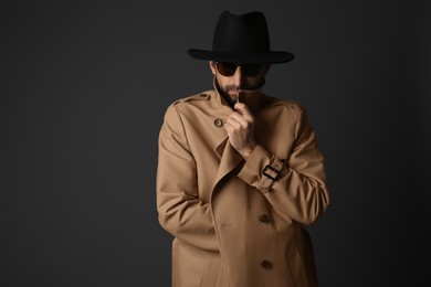 Photo of Exhibitionist in coat and hat on black background