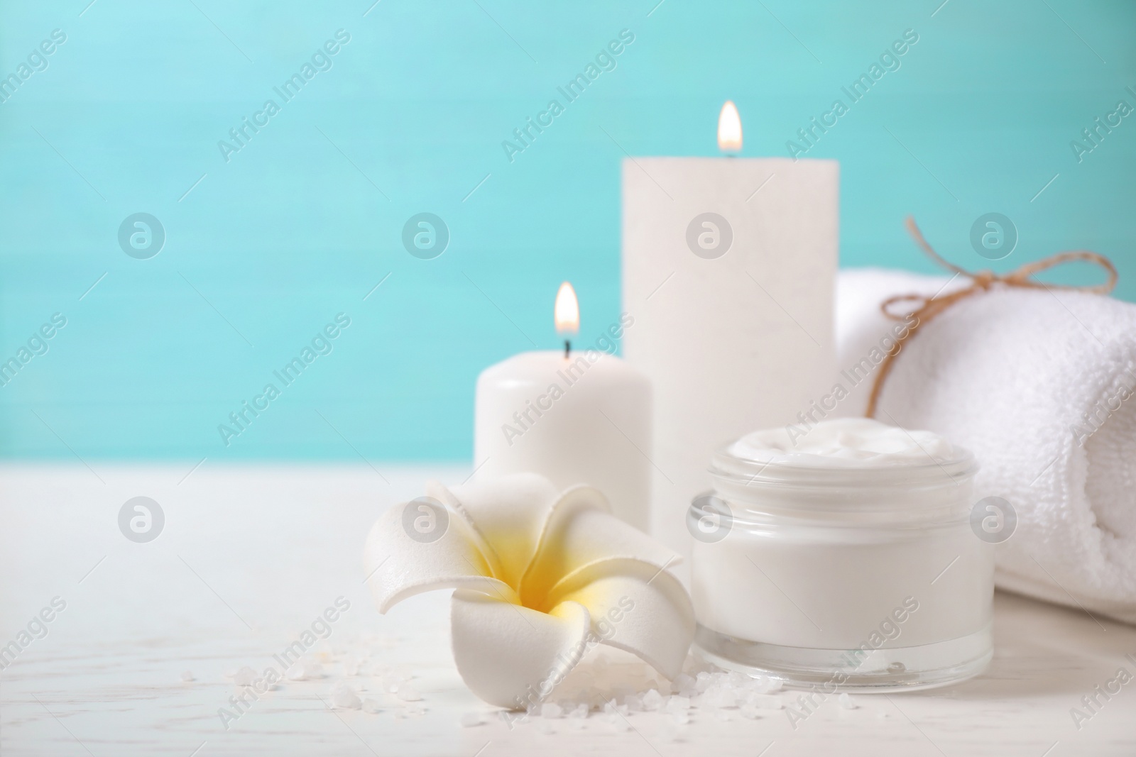 Photo of Composition with cream and burning candles on white wooden table. Spa treatment