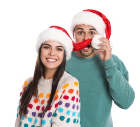 Lovely young couple in Santa hats on white background. Christmas celebration