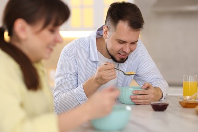 Happy couple having tasty breakfast at home, selective focus