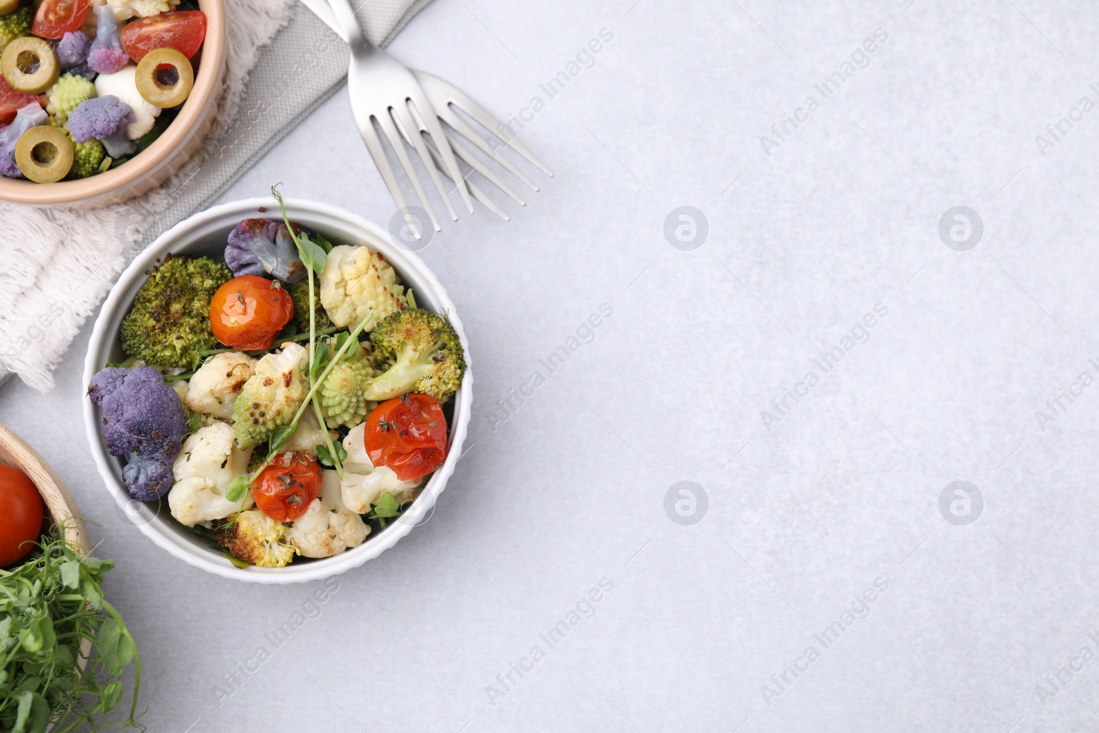 Photo of Delicious salad with cauliflower and tomato served on white table, flat lay. Space for text