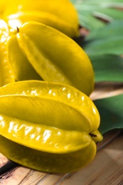 Delicious fresh carambola fruits on wooden table, closeup