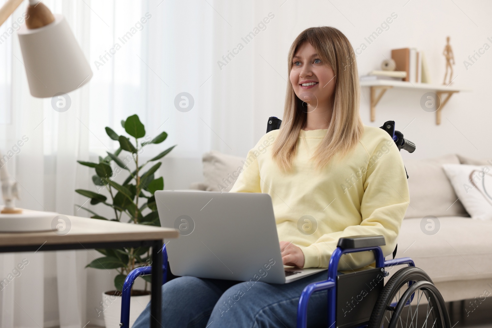 Photo of Woman in wheelchair using laptop at home