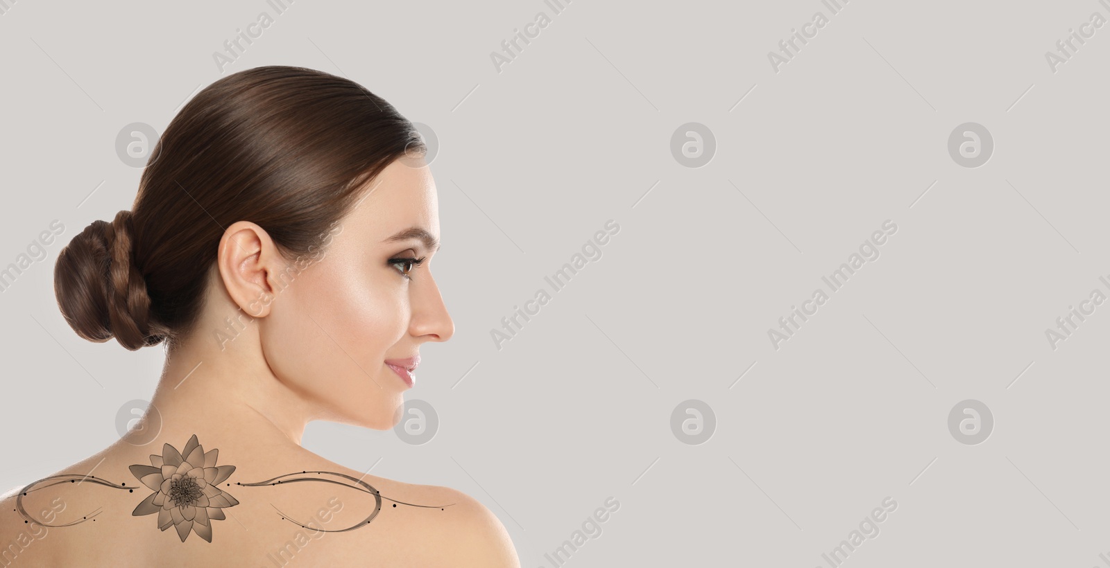 Image of Smiling young woman with beautiful flower tattoo on light background, back view. Banner design with space for text