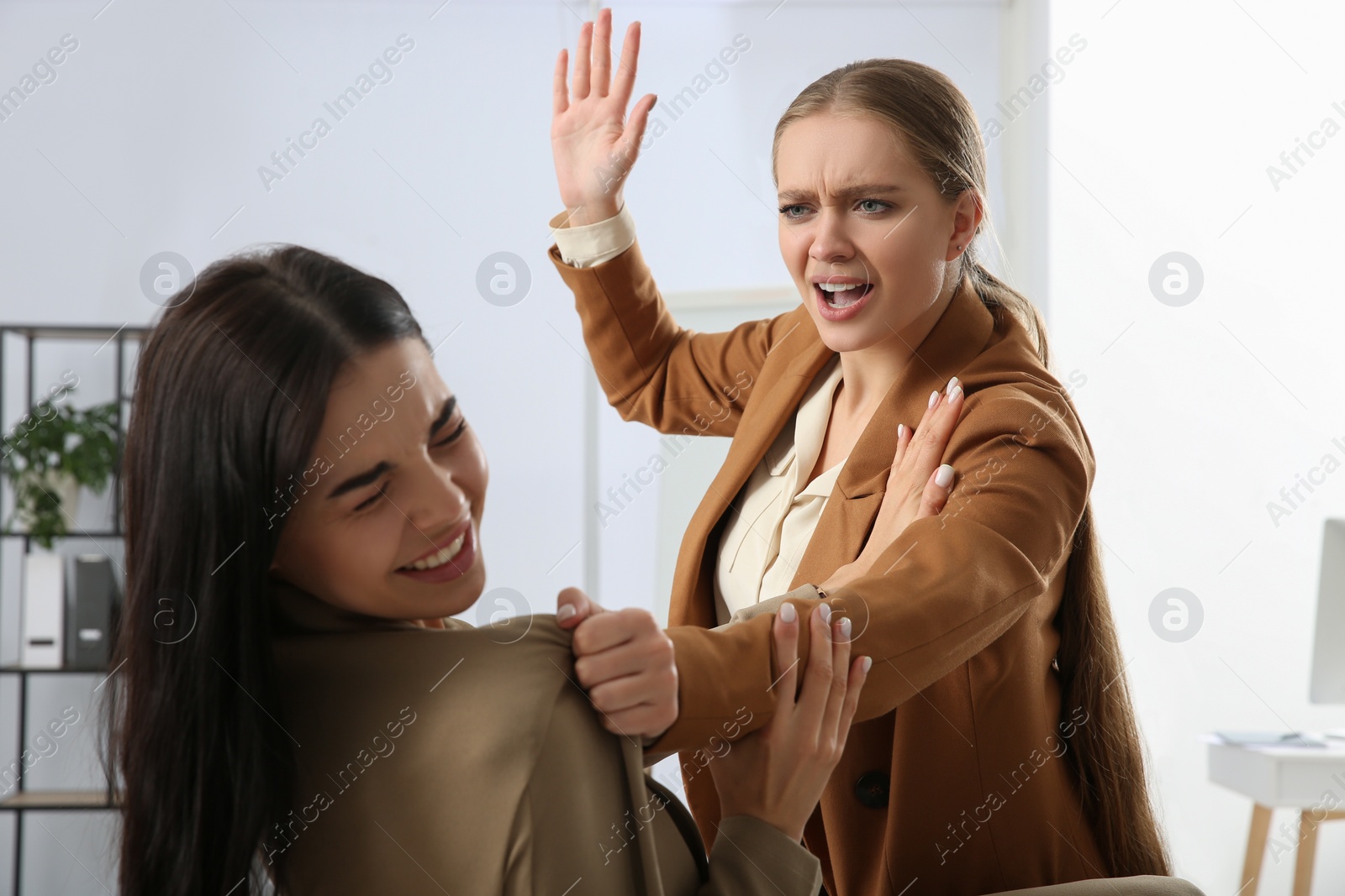 Photo of Emotional colleagues fighting in office. Workplace conflict