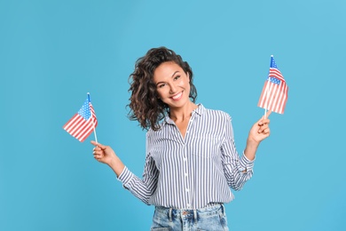 Photo of happy young woman with American flags on blue background