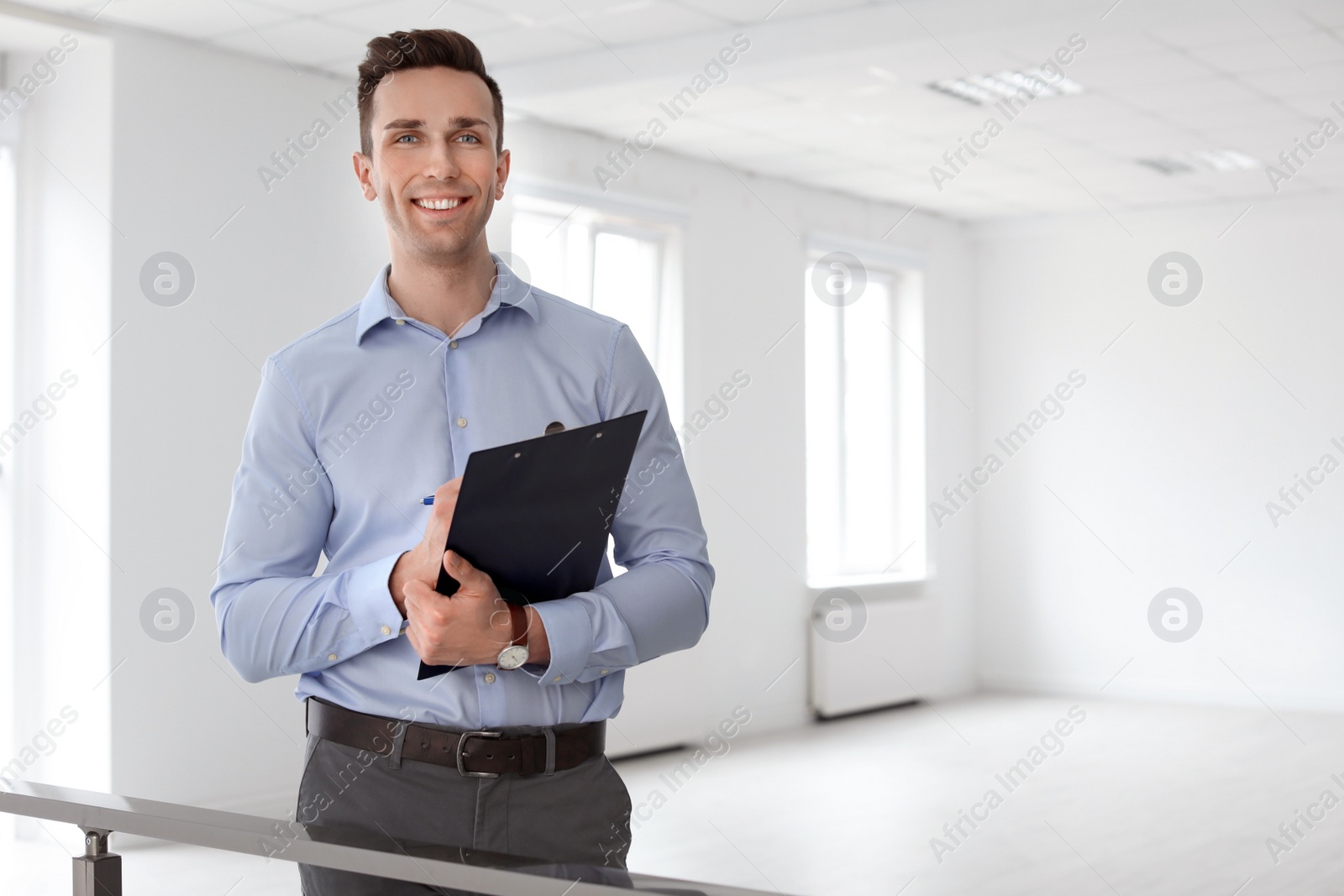 Photo of Male real estate agent with clipboard indoors