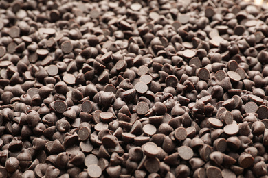 Photo of Delicious chocolate chips as background, closeup view