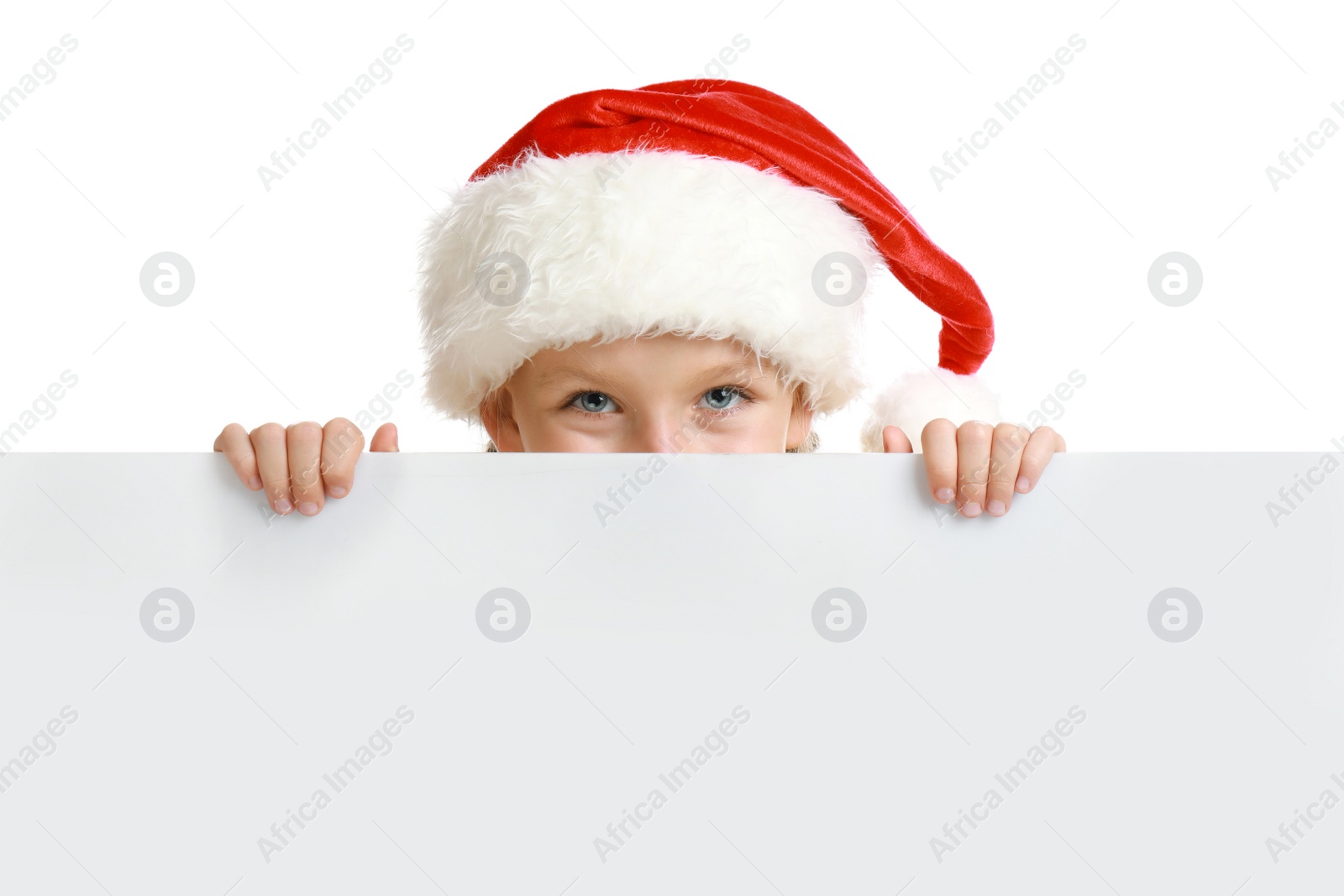 Photo of Happy child in Santa hat peeping out of blank banner on white background. Christmas celebration