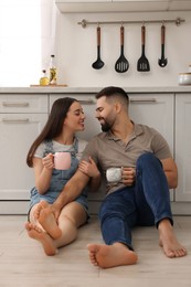 Photo of Affectionate young couple spending time together in kitchen