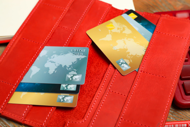 Photo of Credit cards in red wallet on table, closeup