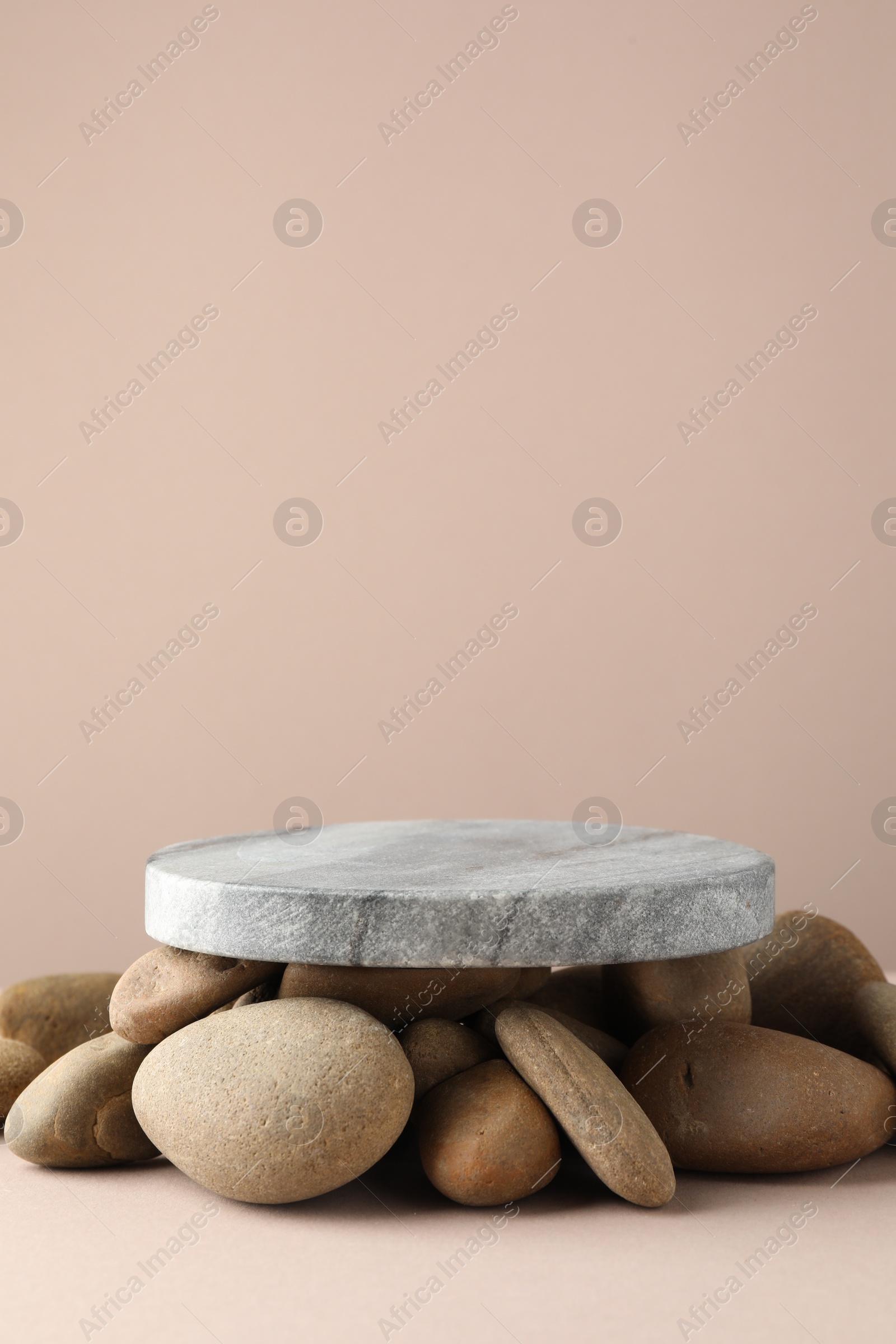 Photo of Presentation for product. Stone podium and pebbles on beige background. Space for text