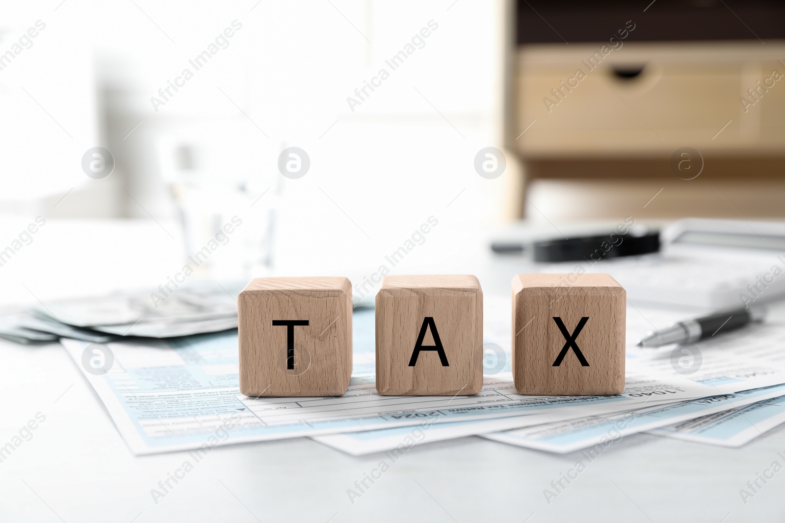 Photo of Wooden cubes with word Tax and documents on light table, closeup. Space for text