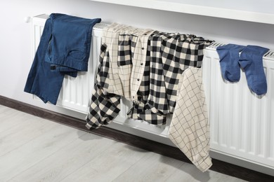 Clothes hanging on white radiator in room