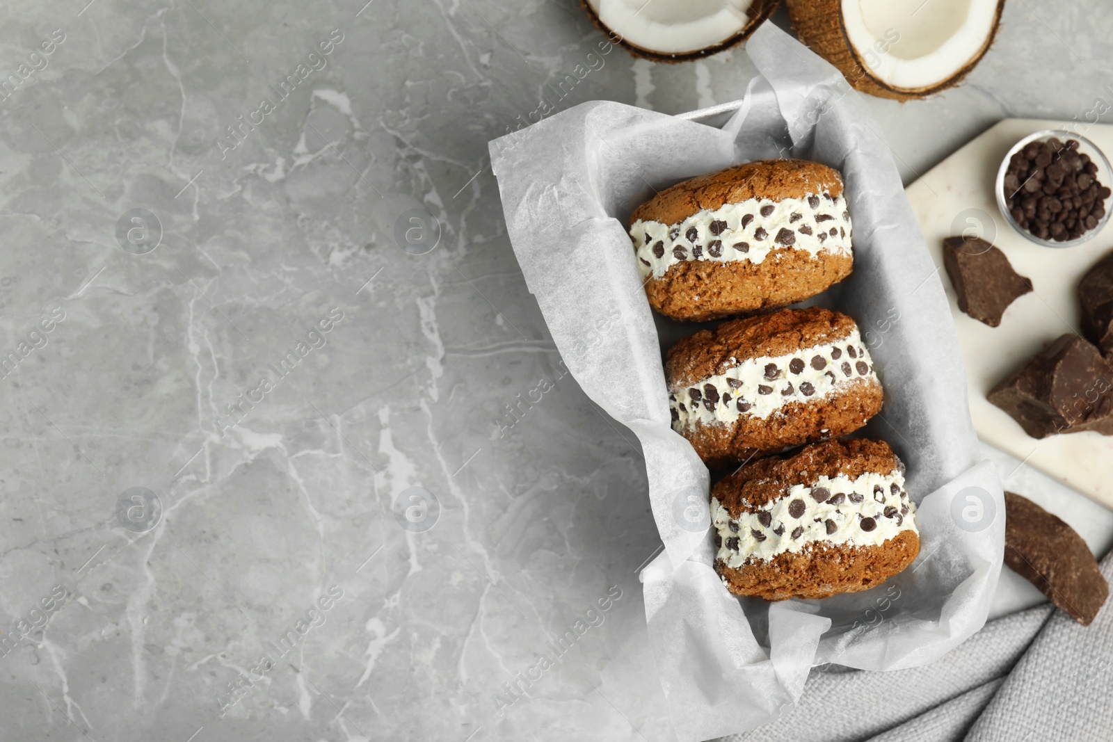 Photo of Sweet delicious ice cream cookie sandwiches on served table, flat lay. Space for text