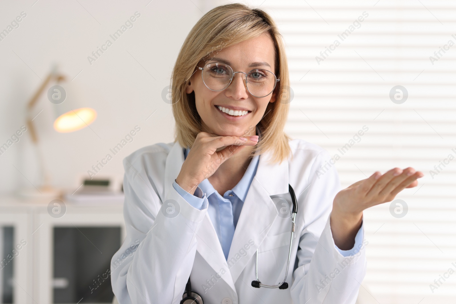 Photo of Portrait of smiling doctor on blurred background