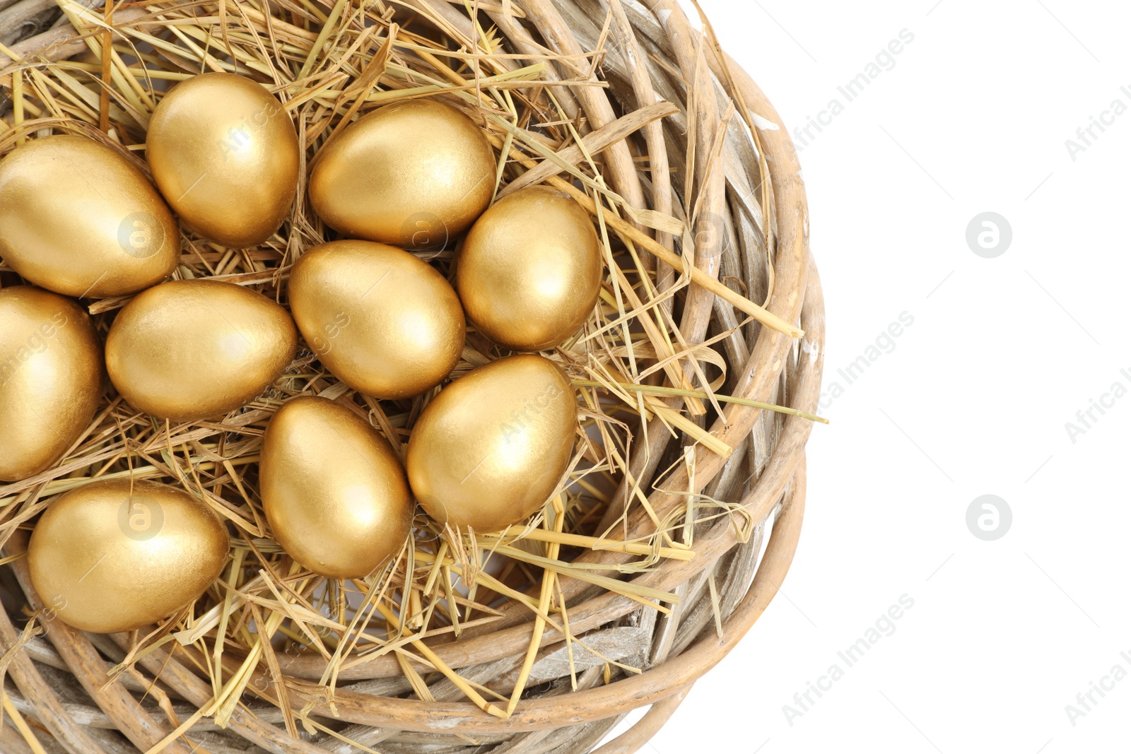 Photo of Shiny golden eggs in nest on white background, top view