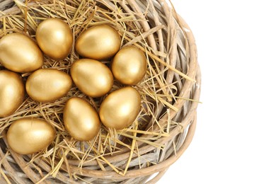 Photo of Shiny golden eggs in nest on white background, top view