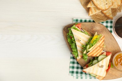 Photo of Delicious sandwiches with vegetables and cheese on white table, flat lay. Space for text