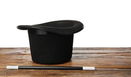 Photo of Magician's hat and wand on wooden table against white background