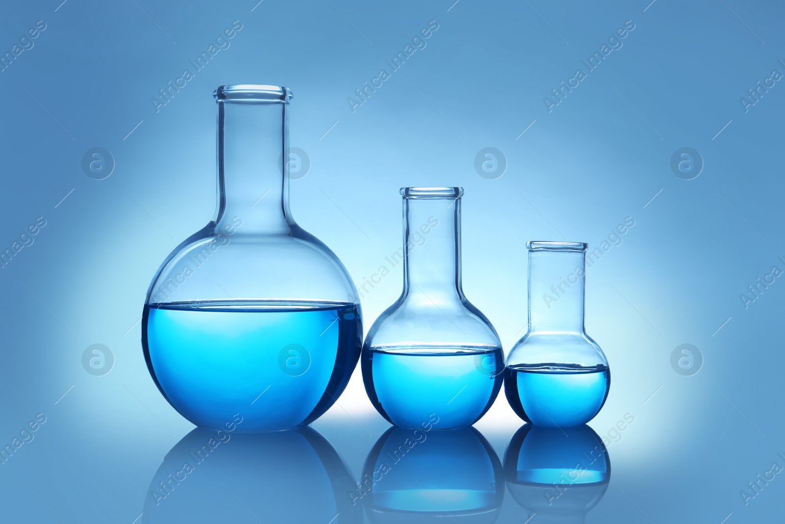 Photo of Flasks with liquid on table against color background. Laboratory analysis