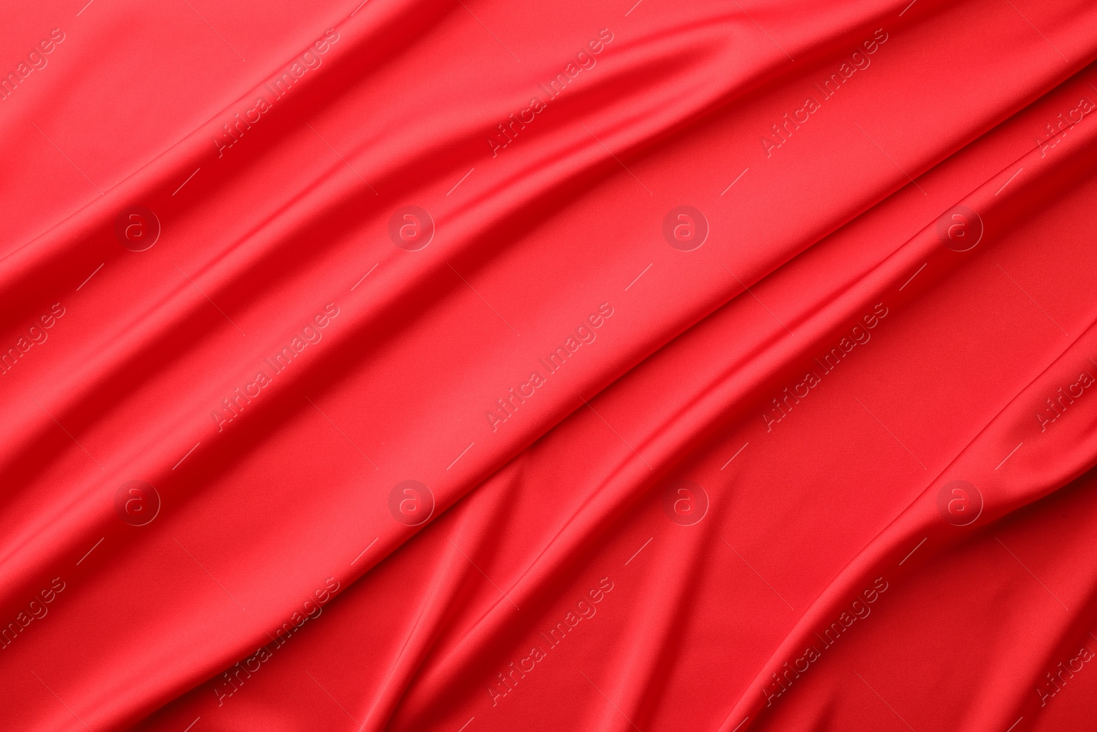 Photo of Crumpled red silk fabric as background, top view