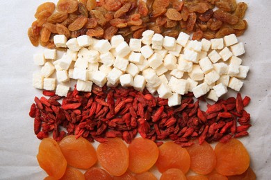 Photo of Different tasty dried fruits on paper, flat lay