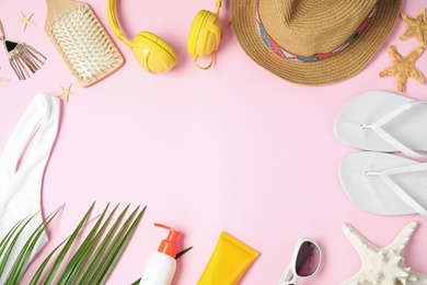 Flat lay composition with beach accessories on pink background, space for text