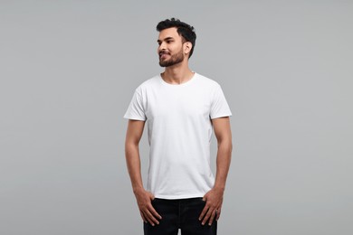 Photo of Smiling man in white t-shirt on grey background