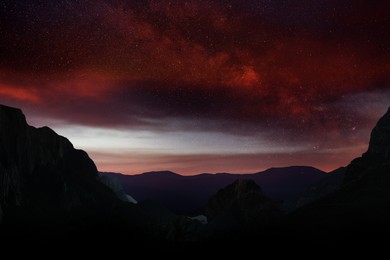 Picturesque view of dawn sky with many stars and clouds over mountains