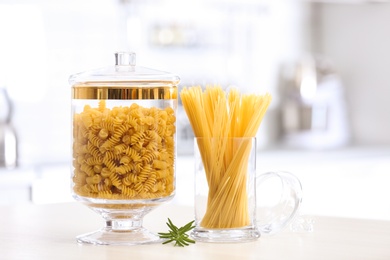 Raw pasta on wooden table in modern kitchen