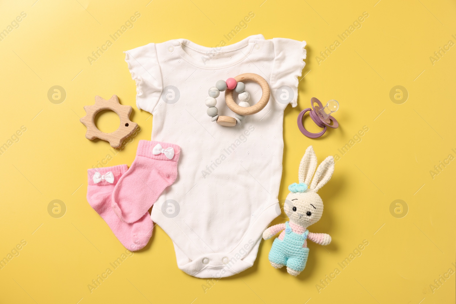 Photo of Different baby accessories on yellow background, flat lay