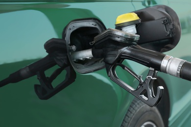 Photo of Refilling car with fuel at gas station, closeup