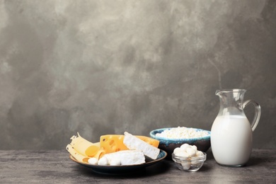 Different dairy products on table against grey background