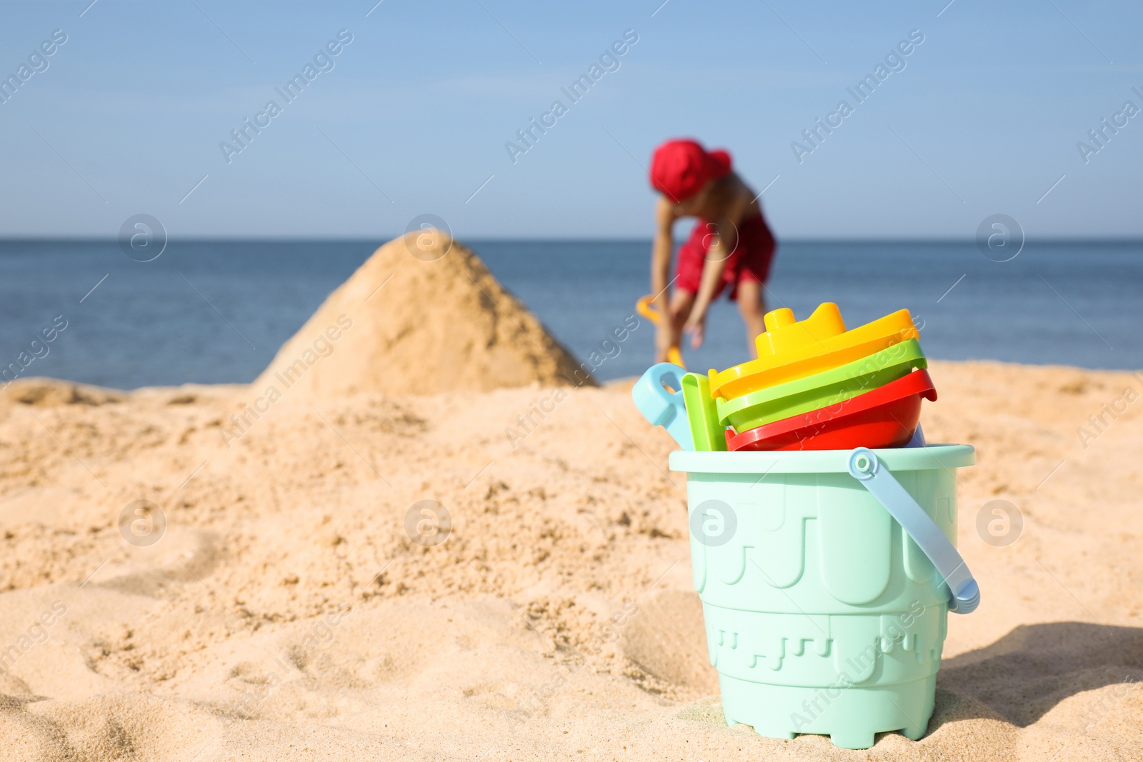 Photo of Different child plastic toys on sandy beach, space for text