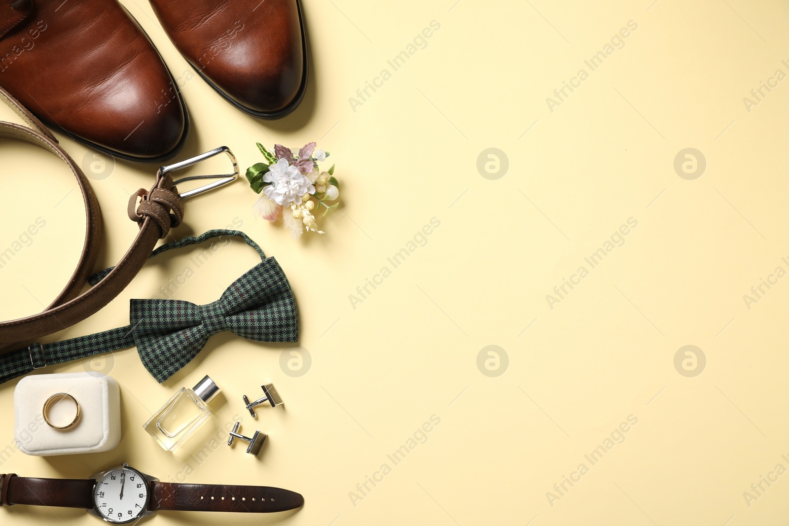 Photo of Wedding stuff. Flat lay composition with stylish boutonniere on yellow background, space for text