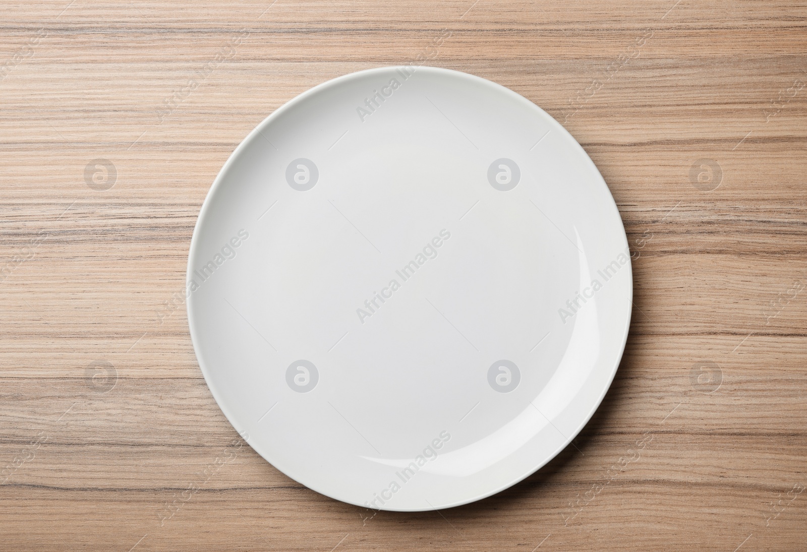 Photo of Stylish ceramic plate on wooden background, top view